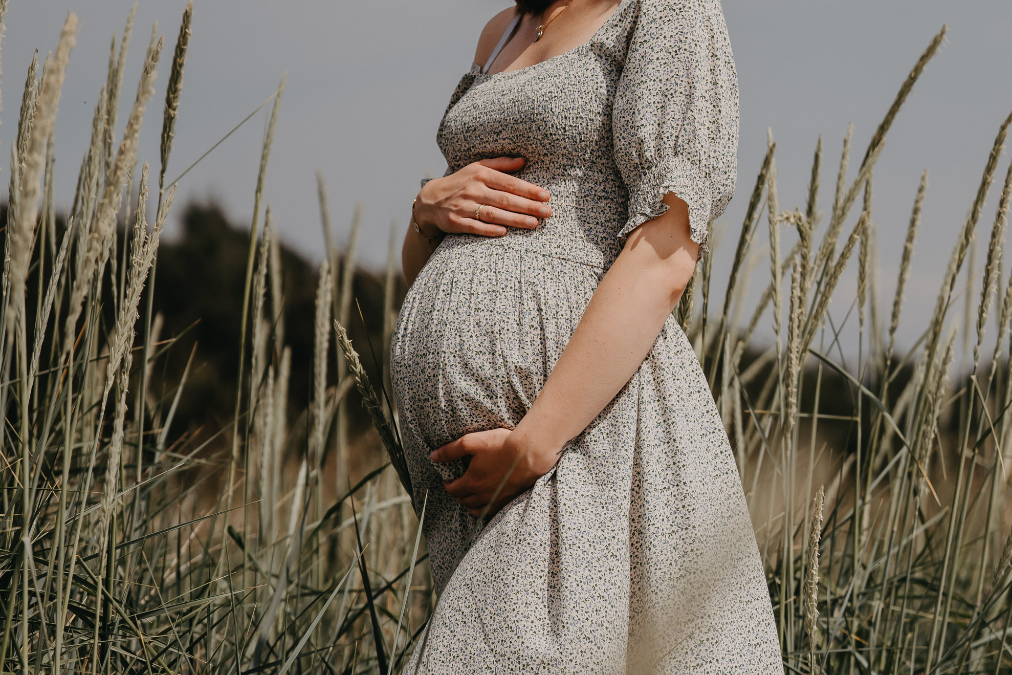 gravid fotografering af kvinde i natur der holder på sin gravide mave